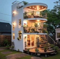 a white house with plants on the balconies