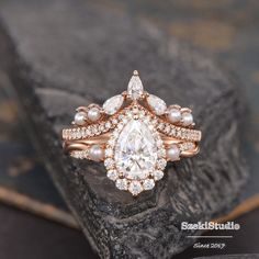 a close up of a ring on top of a rock with diamonds and pearls around it