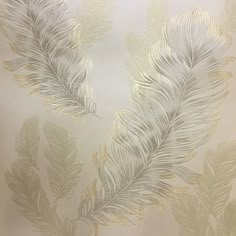 a white and gold feather wallpaper with metallic foiling on the back droplet