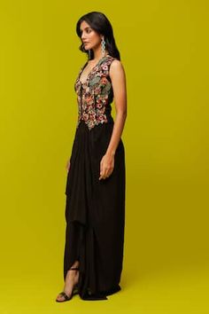 Black waistcoat with multicolor thread embroidery in floral cutwork pattern. Paired with draped skirt. - Aza Fashions Sleeveless Embroidered Navratri Dress, Sleeveless Embroidered Dresses For Navratri, Embroidered Evening Dress For Navratri, Traditional Sleeveless Embroidered Party Dress, Traditional Embroidered Sleeveless Party Dress, Designer Embroidered Front Open Dresses, Multicolor Embroidered Dress With Mirror Work, Fitted Embroidered Dress For Designer Wear, Embroidered Front Open Party Dress