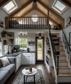 a living room filled with furniture and a stair case in the middle of a kitchen