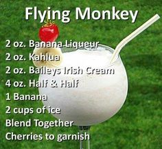 a glass filled with milk and fruit on top of a green grass covered field next to the words flying monkey