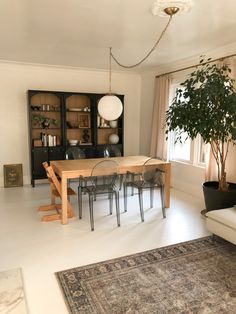 a dining room table and chairs in front of a bookcase with books on it