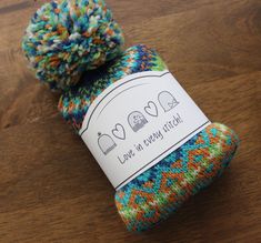 a multicolored knitted sock with a label on it that says love in every stitch