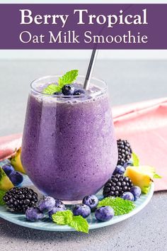 berry tropical oat milk smoothie on a plate with fresh berries and mint leaves