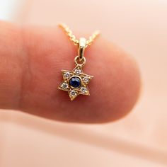 "Magen David - pendant necklace with blue sapphire and diamonds, A Star of David necklace, crafted in 14k gold, a symbol of Jewish faith and heritage, a beautiful piece of Israeli Jewelry. This meaningful Magen David pendant necklace represents the enduring strength and spirit of the Jewish people. The 'Magen David' is an iconic symbol of Judaism, signifying its significance and unity. The blue sapphire signifies Israel's connection, and the gold and diamonds represent the beauty and strength of Sapphire Pendant With Single Cut Diamonds, Elegant Star Of David Gemstone Necklace, Sapphire Jewelry With Single Cut Diamonds For Gift, Sapphire Jewelry With Single Cut Diamonds As A Gift, Star Of David Necklace With Single Cut Diamonds, Dainty Blue Jewelry With Star Charm, Diamond Star Of David Necklace As Gift, Star Of David Necklace With Diamond Accents For Gift, Star Of David Necklace With Diamond Accents As Gift