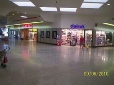 an empty shopping mall filled with lots of items and people walking by it's doors