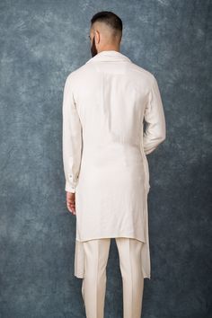 Off white kurta with draped detail and embroidered detail. Paired with pant.
Components: 2
Fabric: Moss Crepe, Cotton Silk
Neckline: Mandarin
Sleeve Length: Full
Color: White
Embroidered
Attached drape
Front button placket - Aza Fashions Elegant Pant Set With Traditional Drape For Eid, Elegant Traditional Drape Pant Set For Eid, Wedding Kurta With Set-in Sleeves For Eid, Elegant Silk Nehru Jacket In Straight Kurta Style, Elegant Straight Kurta With Set-in Sleeves, Elegant Silk Nehru Jacket Straight Kurta, Elegant Semi-formal Straight Kurta Set, Elegant Semi-formal Set With Straight Kurta, White Kurta For Eid Semi-formal