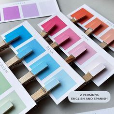 several color swatches are arranged on top of each other with clothes pins attached to them