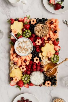 a platter filled with fruit, cereals and other foods on top of a table