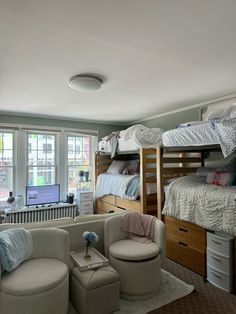 a bedroom with bunk beds and chairs in it