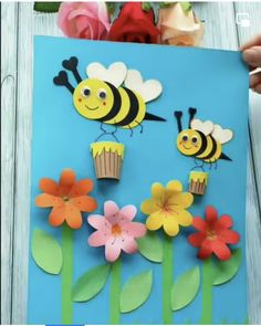 the paper flowers and bees are cut out to look like they are flying over the cupcakes