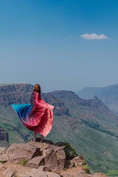 a woman standing on the edge of a cliff