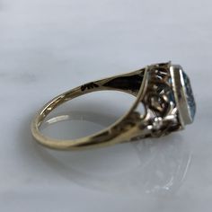 Details: Beautiful vintage aquamarine ring set in 14K yellow gold filigree. There are sweet little hearts and fleur-de-lis details. The setting looks Edwardian, with delicate yellow and white gold filigree. The pretty aquamarine measures 7.6mm x. 5.9mm. The ring sits off the finger 5.8mm. The inside is stamped 14K. Measurements: Ring measures a size 6 US. It can be re-sized for a fee. Condition: The overall all condition of this ring is very good. Please ask all questions prior to placing an ord Vintage Gold Filigree Ring With Diamond Accents, Vintage 14k Gold Filigree Ring With Diamond Accents, Vintage Gold Topaz Ring With Rose Cut Diamonds, Vintage Gold Topaz Promise Ring, Vintage Formal Topaz Ring With Diamond Accents, Vintage Round Topaz Ring With Filigree, Vintage Topaz Ring With Filigree, Vintage Oval Filigree Ring With Rose Cut Diamonds, Vintage Filigree Ring With Rose Cut Diamonds