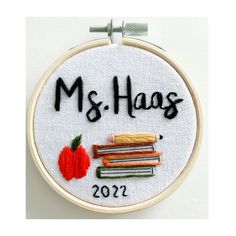 a cross stitch pattern with the words ms - hags and a stack of books