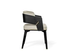 a black and white chair with gold trimmings on the back, sitting in front of a white background