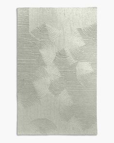 a square rug with wavy lines on the bottom, and an abstract design in grey