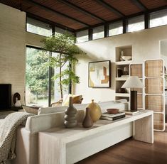 a living room filled with furniture and a large window covered in lots of natural light