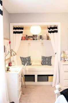 a bedroom with a bed, desk and window in the corner that has curtains over it