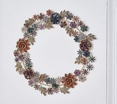 a wreath made out of various flowers on a white background with the letter o in the center