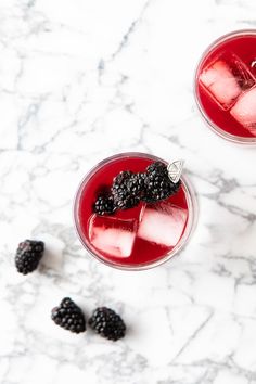 blackberry bourbon whiskey sour recipe in a glass with ice and blackberries on the side