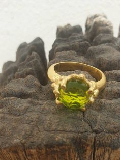 This is gold plated brass peridot ring. A designer handmade ring. It has a design of a coral, holding a green peridot gem. It could be an alternative engagement ring, or a great gift for a loving one. - 14 karat Gold plated brass - Round peridot gem - Free shipping worldwide - Sent in a gift box If you would like to see other rings I have made, please follow this link: https://www.etsy.com/il-en/shop/TamyZurTachshit?ref=seller-platform-mcnav&section_id=17271018 If you would like to go back t Gold Plated Green Rings For Gift, Green Gold Plated Rings For Gift, Elegant Handmade Peridot Rings, Handmade Elegant Peridot Rings, Formal Lime Green Ring, Unique Green Peridot Rings, Elegant Green Peridot Crystal Ring, Green Gemstone Ring Gold-plated, Green Gemstone Gold Plated Rings