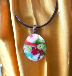 There are lots of different glass colors in this one of a kind, handmade pendant! And it is sure to brighten your day when you wear this happy piece of glass art. This sweet glass pendant measures about 1 inch wide by 1 1/4 inch tall, it has an antiqued silver bail attached and is hung on a leather necklace. There are two millefiori leaves and a red flower millefiori in the center.   This is a one of a kind art glass pendant and like all of my glass pendants, was made by me using my own handmade Handmade Multicolor Oval Pendant Necklace, Handmade Multicolor Necklace From Recycled Glass, Handmade Multicolor Necklaces From Recycled Glass, Multicolor Recycled Glass Jewelry As A Gift, Multicolor Recycled Glass Jewelry For Gifts, Unique Murano Glass Necklace For Gift, Handmade Czech Glass Round Pendant Necklace, Unique Murano Glass Necklaces As Gifts, Handmade Czech Glass Necklace With Round Pendant