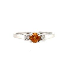 This beautiful 14K white gold ring brings all of the attention to its centerpiece, a 4mm round-cut citrine. The citrine is highlighted by a brilliant round-cut diamond on each side. 14K White Gold Citrine: Round-cut, 4x4mm Diamond: 2 Round-cut Finger Size: 6.75 White Gold Citrine Diamond Ring With Accent Stones, White Gold Diamond Ring With Citrine Accent Stones, Orange Diamond Ring With Prong Setting, Orange Diamond Topaz Ring With Center Stone, Orange Topaz Ring With Diamond Center Stone, Classic Orange Topaz Round Ring, Classic Orange Ring With Accent Stones, Classic Orange Diamond Ring, Round Citrine Diamond Ring With Brilliant Cut