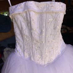 a white corset with sequins and beads on the bottom is displayed