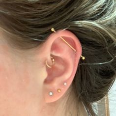 a close up of a person's ear with two piercings on top of it