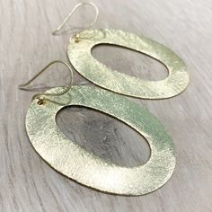 "These handcrafted earrings are modern and chic! Large gold circular hoops measuring over 2 inches long by 1.5 inches wide dangle from matching fish hooks. Earring material is brass dipped in brushed gold and lacquered with a protective varnish to prevent tarnish. Such beautiful texture! The earrings measure approximately 2.75\" in total length. A fabulous chunky look in a super lightweight style! Item is carefully packaged and shipped via USPS in a sturdy protective mailer. Check out more fabul Modern Oval Metal Earrings, Chic Handmade Gold Earrings, Chic Gold Handmade Earrings, Modern Hammered Earrings For Parties, Modern Hammered Earrings For Party, Chic Hammered Metal Earrings, Handmade Gold Oval Hoop Earrings, Handmade Oval Gold Hoop Earrings, Chic Gold Oval Hoop Earrings