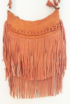 This casual crossover bag is your next best friend! With a top zip closure and back zip pocket, this small bag can easily fit all your everyday items in it. The front features a faux leather cross stitch detail with a fun boho suede fringe that hangs about 10" long. The shoulder bag has a 45" strap and interior zip pocket. So grab a girlfriend and go exploring in the 'City of Austin' with this must have accessory to go with your favorite denim. Available in camel. Vegan leather and suede. 9" x 8 Trendy Saddle Bag With Removable Pouch For Shopping, Casual Rectangular Bag With Fringe, Pouch Satchel With Braided Handles For Shopping, Casual Fringe Bags For Daily Use, Braided Handles Pouch Shoulder Bag For Shopping, Casual Rectangular Fringed Shoulder Bag, Trendy Brown Saddle Bag For Shopping, Trendy Rectangular Bag With Fringe, Chic Saddle Bag With Adjustable Strap For Shopping