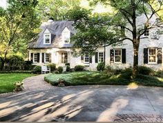 a white house surrounded by trees and grass