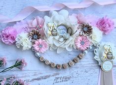 a bunch of flowers that are next to some ribbon on a white wooden table with pink and brown ribbons