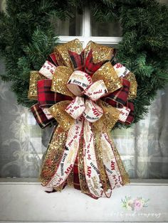 a red and gold christmas wreath sitting on top of a window sill