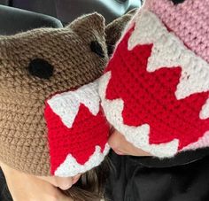 two crocheted hats with red and white designs on them, one has a bear