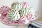 three cupcakes with white frosting and sprinkles in a glass dish