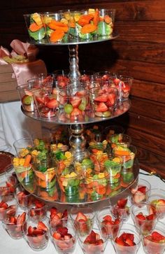 three tiered trays filled with different types of fruit on top of a table