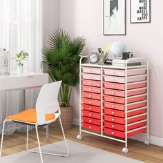 a white chair sitting next to an orange and pink drawer on top of a wooden table