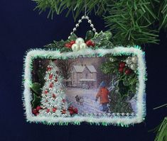 an ornament hanging from a christmas tree decorated with lights and decorations, depicting a boy walking his dog in the snow