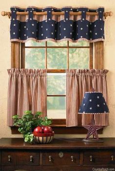 the window is decorated with blue and white stars on it's valance, along with a potted plant