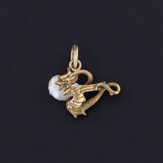 Antique Dragon Charm: Unlock the magic of ancient lore with this enchanting charm, crafted from 14k gold and adorned with a lustrous pearl. Originally an antique stickpin from circa 1890, our skilled jeweler transformed it into a charm by removing the pin and adding a 14k gold jump ring bail. The petite charm measures 0.6 inches from the top of the jump ring to bottom by 0.5 inches wide, and it is in great condition. We have many other fantastic offerings of period fine and costume jewelry poste Bespoke Rings, Jewelry Post, Antique Shops, Jewelry Findings, Pendant Necklaces, Costume Jewelry, Antique Jewelry, 6 Inches, Jewelry Necklace Pendant