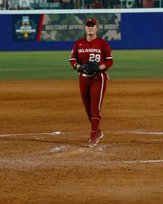 a female baseball player is walking on the field