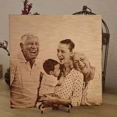 a wooden photo frame with an image of two adults and a child