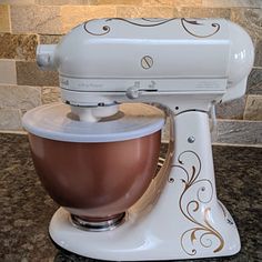 a white mixer sitting on top of a counter next to a tile backsplash