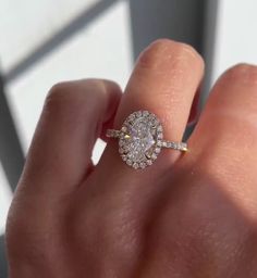 a woman's hand with a diamond ring on top of her finger and an engagement band