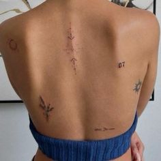 the back of a woman's body with tattoos on her upper and lower back