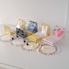 three miniature baby cribs with animals in them on top of a white surface