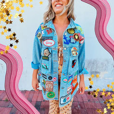 a woman standing in front of a wall with gold stars and confetti on it