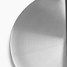 a black and white photo of a metal plate with a knife sticking out of it